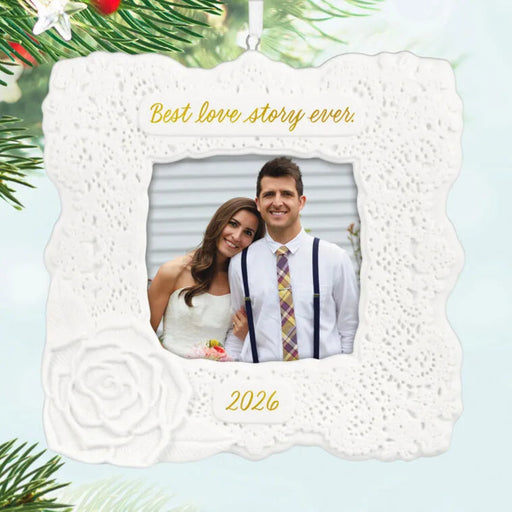 Decorative photo ornament with a couple's picture and 'Best love story ever' text, surrounded by Christmas tree branches.