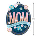 Decorative sign with 'MOM' and floral design, featuring a quote on a white background.