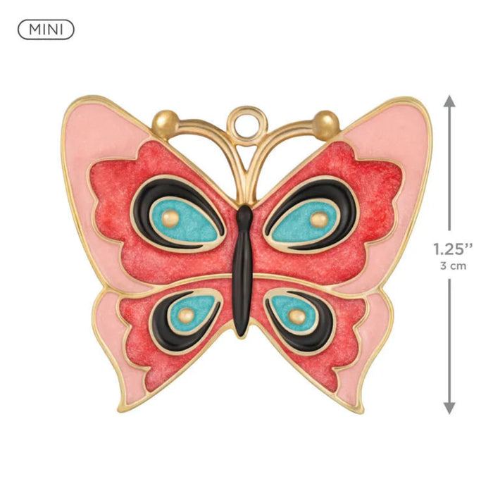 Butterfly-shaped ornament  with gold frame, red wings, and blue centers on a white background.