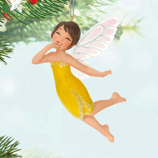 Fairy ornament with yellow dress and white wings on a light blue background