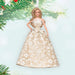 Barbie doll ornament in a gold and white dress hanging on a Christmas tree.
