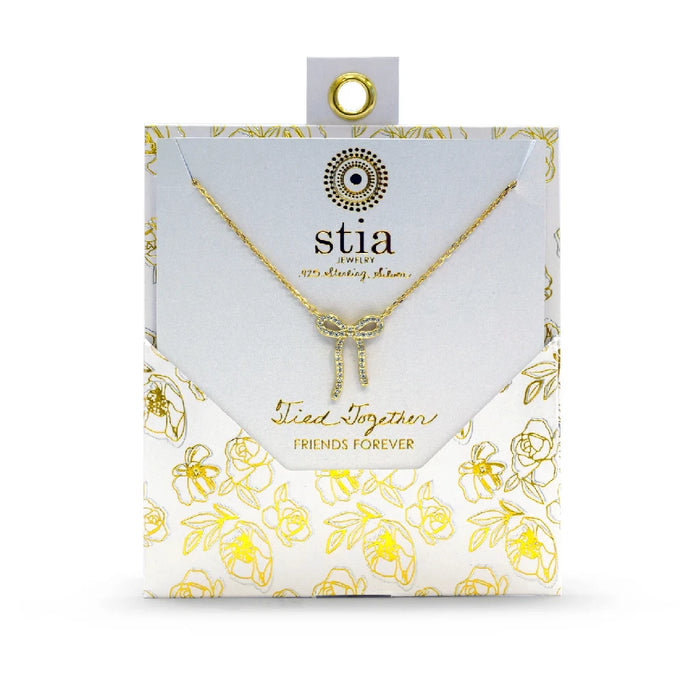 A gold chain necklace adorned with a diamond bow, highlighting its luxurious and stylish appearance.