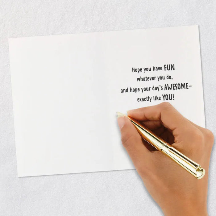 Hand holding a gold pen over a white card with a motivational message on a light gray background