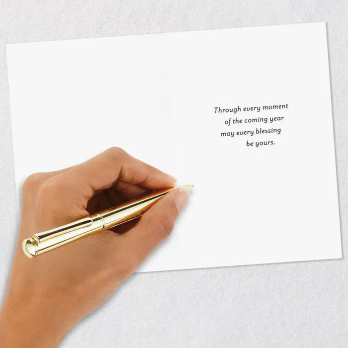 Hand holding a gold pen over a white card with a message on a light gray background