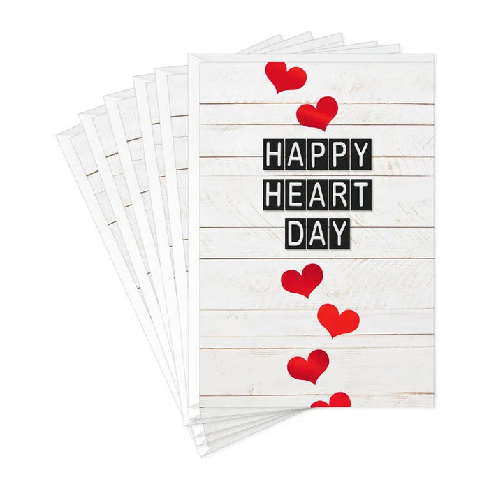 Stack of greeting cards with 'Happy Heart Day' text and red hearts on a white background