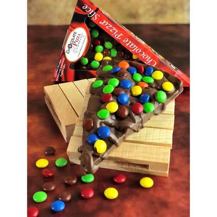 Chocolate pizza slice with colorful M&M's on a wooden stand, packaging visible.