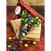 Chocolate pizza slice with colorful M&M's on a wooden stand, packaging visible.