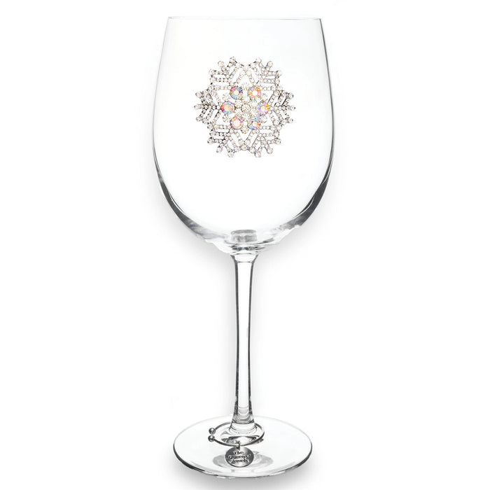 Clear wine glass with decorative emblem on a white background