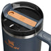 Blue Stanley travel mug with a brown handle on a white background