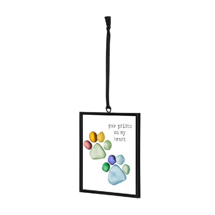 A black frame containing a dog's paw print, capturing a cherished memory of a furry friend.