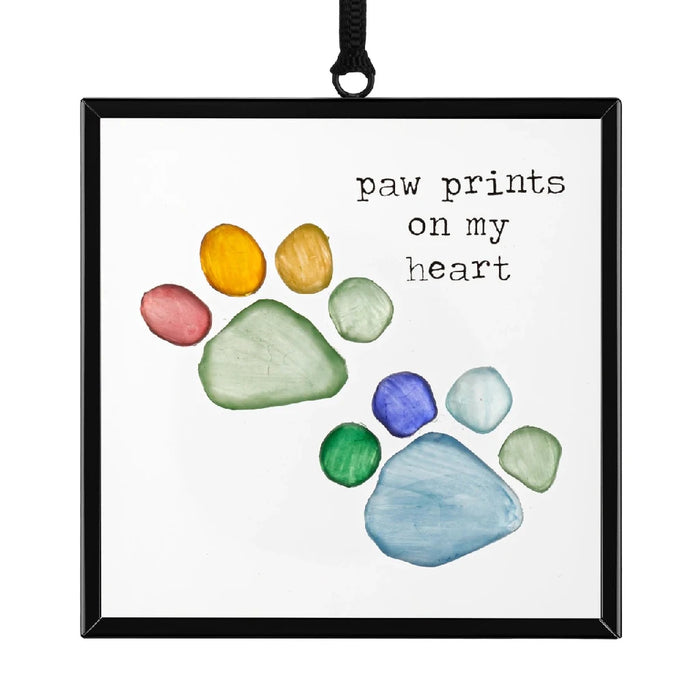 A black-framed image featuring a dog's paw print, representing a beloved pet's presence.