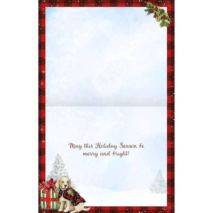 Christmas card with a dog in a sweater and presents, framed by a red border with holly leaves.