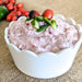 A vibrant cranberry jalapeño spread mix in a jar, featuring a rich red color and visible jalapeño pieces for flavor.