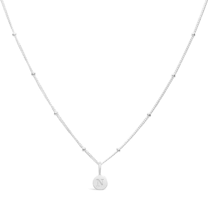 Stia Couture Mini Love Letter N Necklace featuring an engraved N initial pendant in .925 sterling silver with rhodium plating on a delicate Saturn chain.