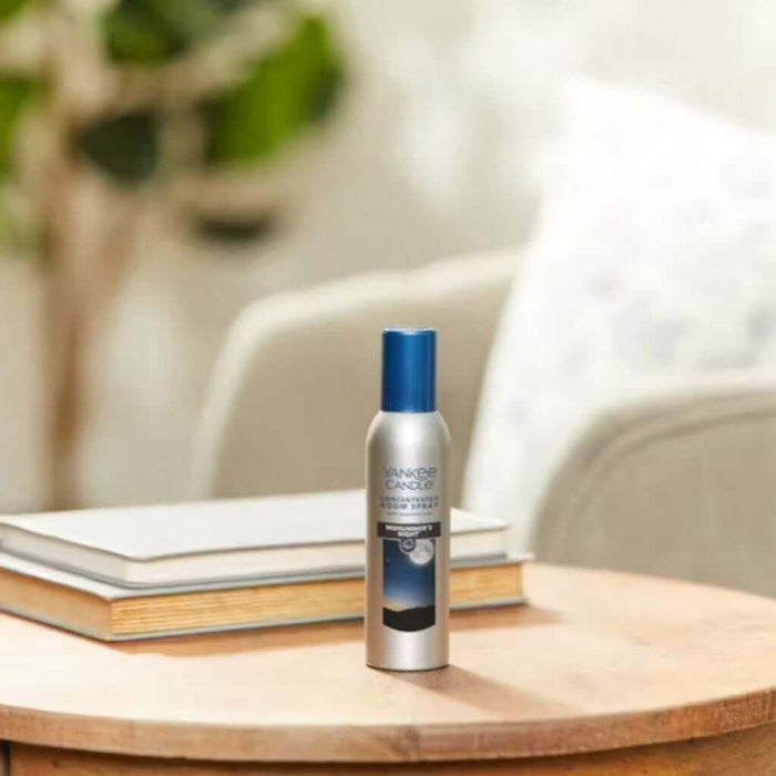Yankee Candle Room Spray bottle on a wooden table with a blurred background