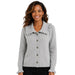 A smiling woman wearing a light gray knit cardigan with a large ruffled collar and front buttons, paired with black pants, against a plain white background.