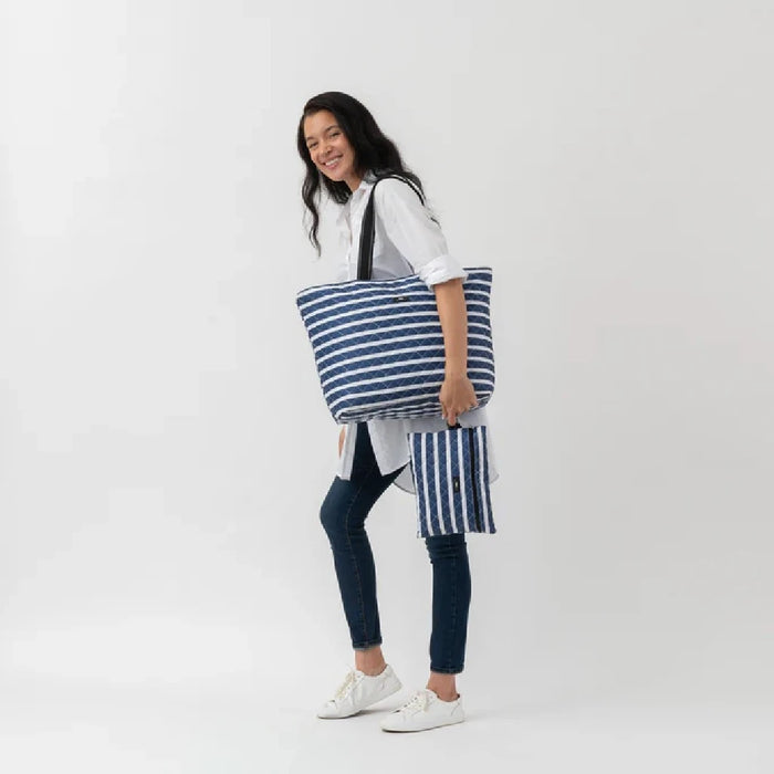 A blue and white striped tote bag with a matching pouch, offering a chic and functional accessory for daily use.