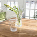 1. A table featuring a vase of colorful flowers alongside a clear glass of water.
