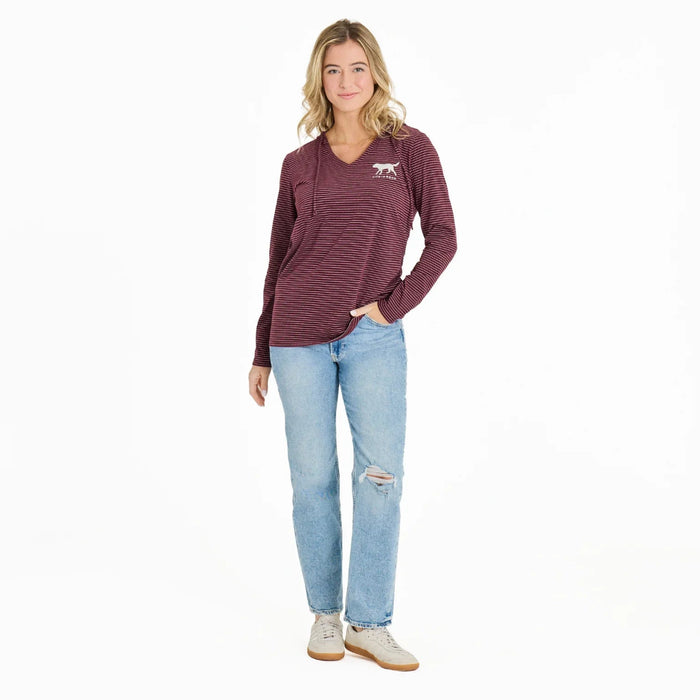 Woman wearing a maroon striped long-sleeve shirt and light blue jeans on a white background