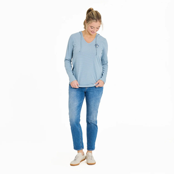 Woman wearing a light blue long-sleeve shirt and jeans on a white background