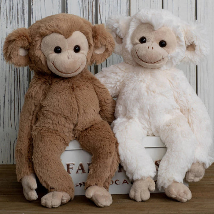 A soft, stuffed monkey set on a white surface.
