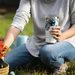 Person holding Tervis Kelly Ventura Protea tumbler with slider lid while gardening