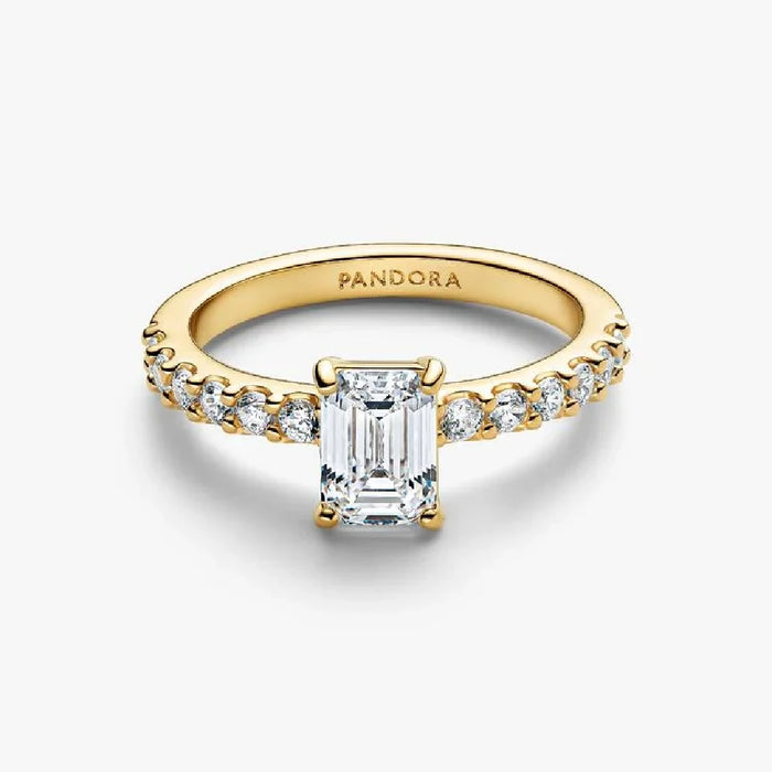 An emerald cut diamond engagement ring set in yellow gold, showcasing a classic and elegant design.