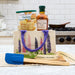 Stonewall Kitchen products including syrup, pancakes, and a tote bag with lavender design on a kitchen counter.