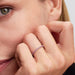 Close-up of a woman’s hand wearing the Pandora Sparkling Pink Band Ring in sterling silver with pink stones.