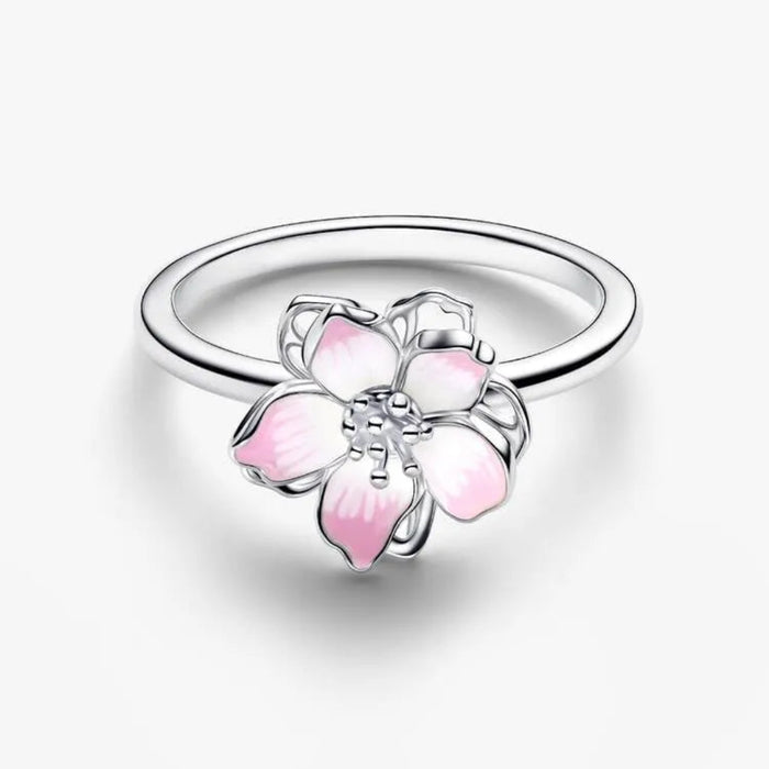 Silver ring with a pink flower-shaped charm on a white background