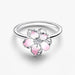 Silver ring with a pink flower-shaped charm on a white background