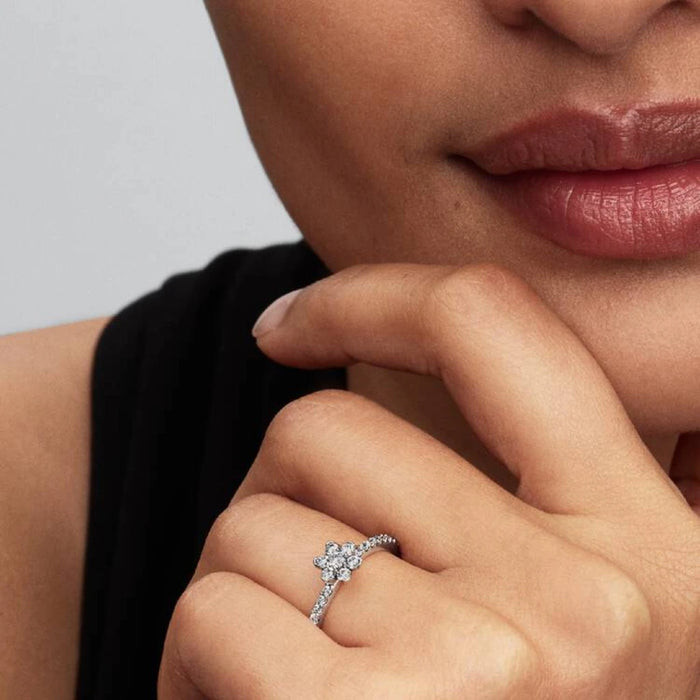 A diamond flower ring crafted with a white gold band, featuring a unique floral design embellished with sparkling diamonds.