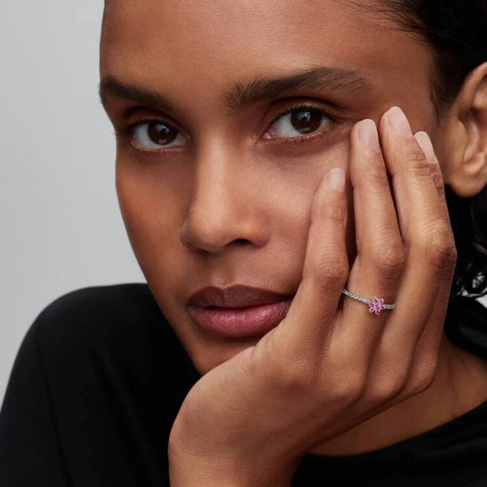 A delicate Pandora flower ring with a pink sapphire, elegantly crafted in white gold.