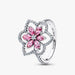 A pink flower ring adorned with diamonds and pink sapphires, showcasing intricate floral design and vibrant colors.