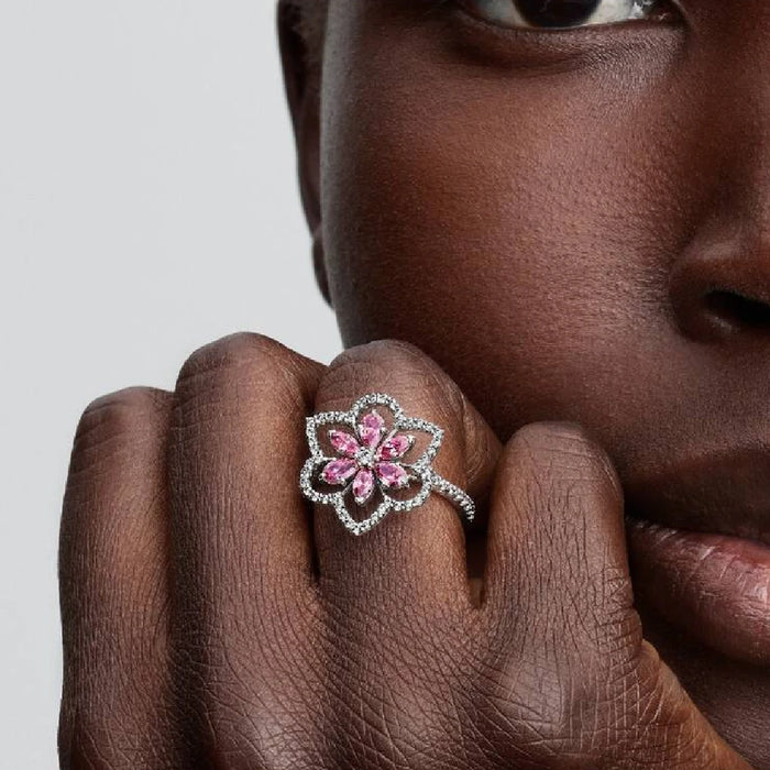 A beautiful pink flower ring with diamond and pink sapphire accents, capturing the essence of floral elegance.