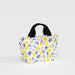 A small white tote bag featuring a vibrant lemon pattern on its surface.