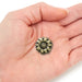 Bronze sunflower pocket token displayed in a person’s hand to show scale