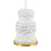 Decorative white cake ornament with gold base and '2025' on a white background