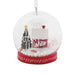 Hallmark Cozy Holiday Wishes Snow Globe Christmas ornament featuring a red log cabin, snowy roof, decorated evergreen tree, and swirling white snowballs.