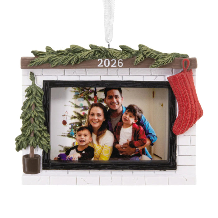 Hallmark Cozy Fireplace 2026 Photo Frame Christmas ornament featuring a festive fireplace with greenery, red stocking, miniature evergreen tree, and photo holder.