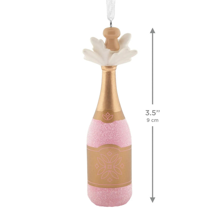 Hallmark Pink Champagne Christmas ornament featuring a gold-wrapped bottle with sparkling pink champagne bubbles bursting from the cork.