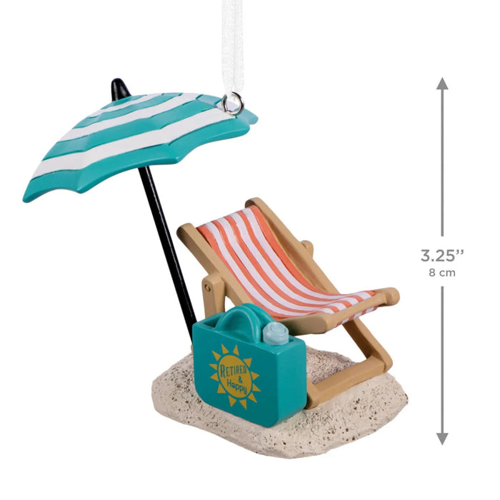 Hallmark Retired and Happy Christmas ornament featuring a beach chair, umbrella, sand, and beach bag with “Retired & Happy” message.