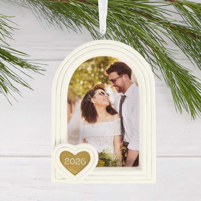 Hallmark Wedding 2026 Christmas ornament featuring a white arched photo frame with a gold heart attachment and year-dated 2026 design for newlyweds.