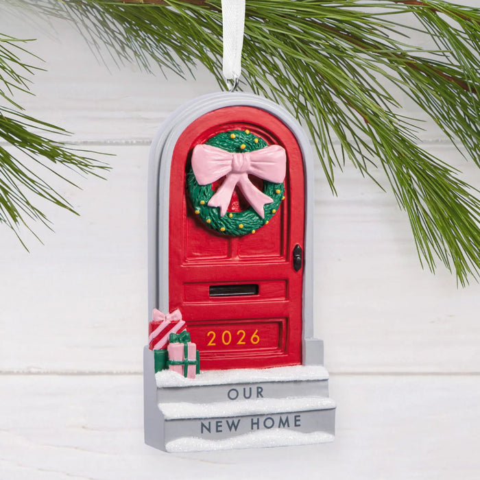 Hallmark Our New Home 2026 Christmas ornament featuring a red front door with a festive wreath, snow-covered steps, and wrapped gifts.