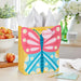 Large yellow Mother’s Day gift bag with pink and blue butterfly design displayed on a table beside a greeting card