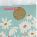Close‑up of blue daisy Mother’s Day gift bag with gold accents