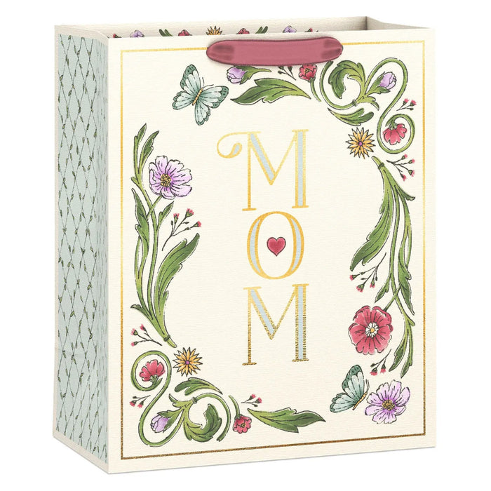 Large linen-textured Mother’s Day gift bag with gold foil “Mom” lettering, floral and butterfly illustrations, and a small red heart.