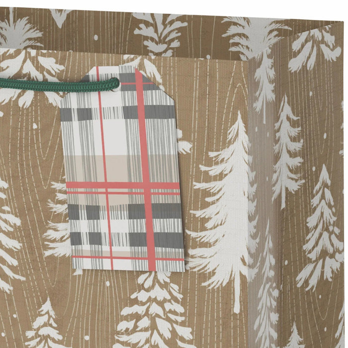 9.6-inch medium Christmas gift bag featuring white trees on a woodgrain kraft background with an included gift tag.