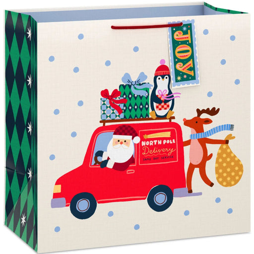 15-inch extra-deep Christmas gift bag featuring a festive Santa delivery truck design with an included gift tag.