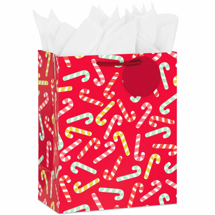 9.6-inch medium red Christmas gift bag featuring candy cane designs with tissue paper.